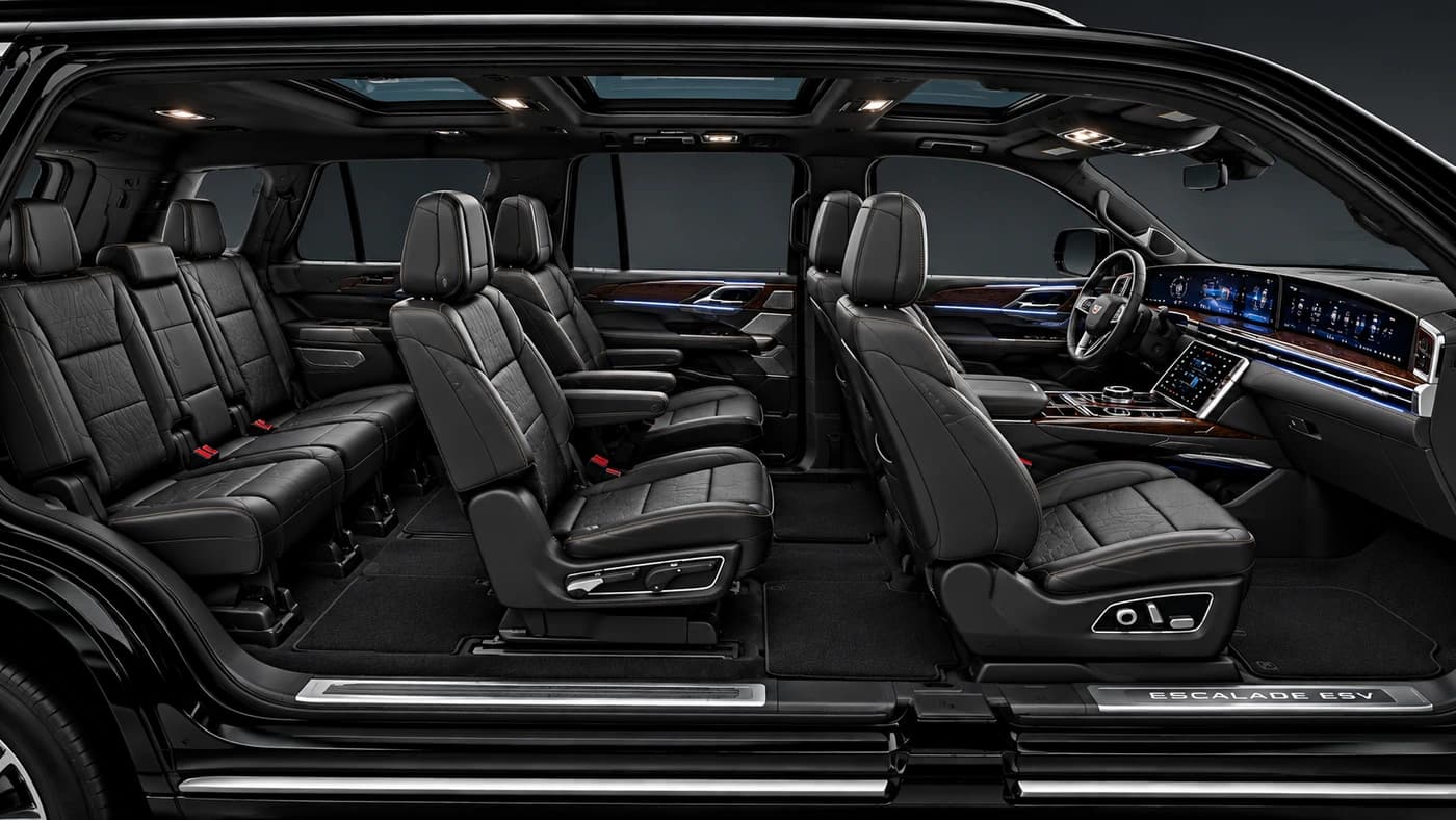 Cadillac Escalade interior with black leather seats and a digital dashboard, seen through an open door.