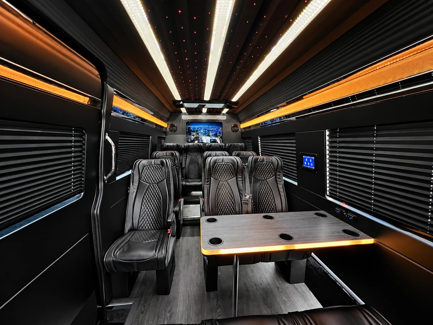 Mercedes-Benz Executive Sprinter black leather seats arranged around a table.