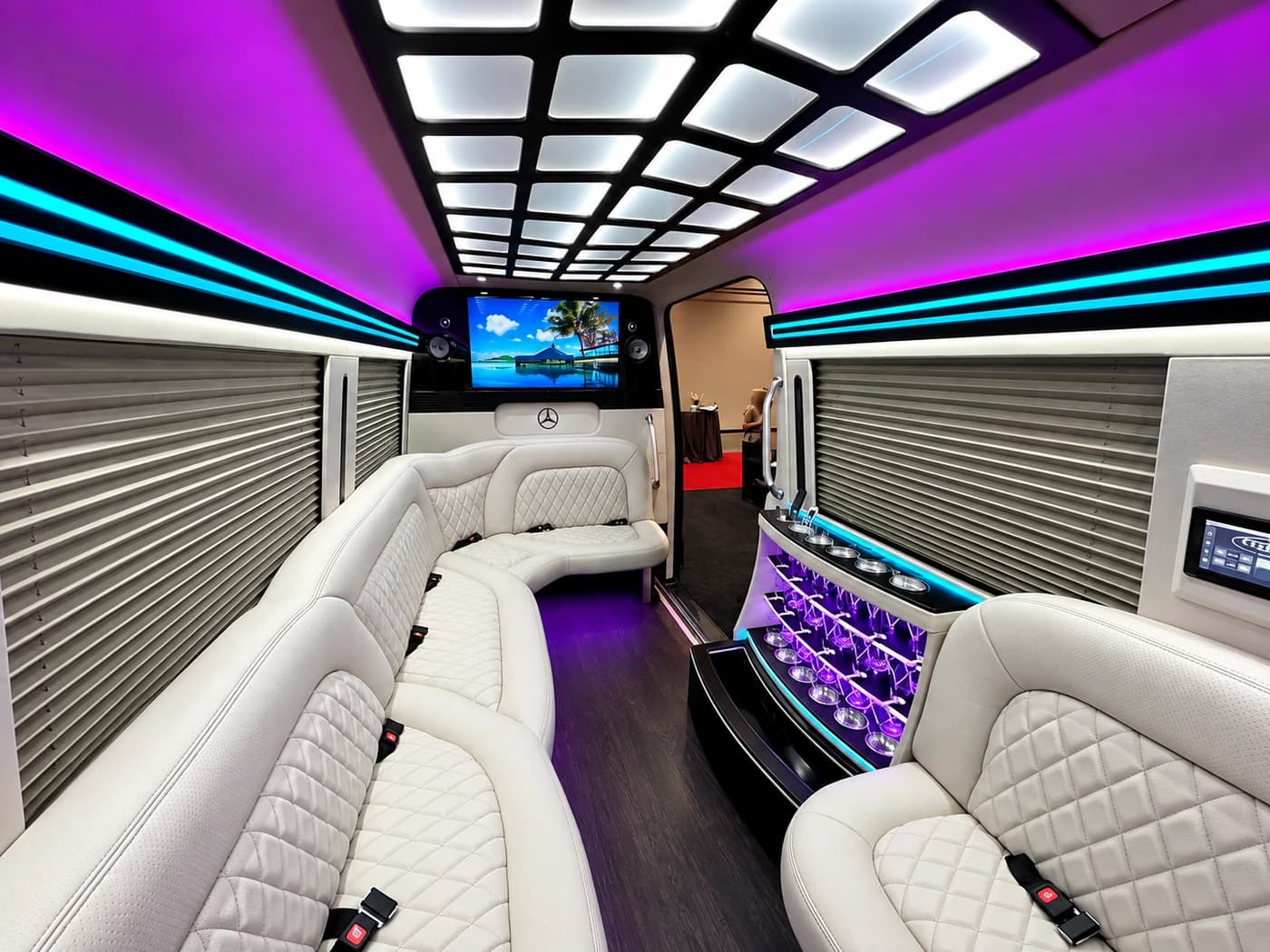 Mercedes-Benz Party Limo Sprinter interior with white leather seats, purple lighting and a bar.