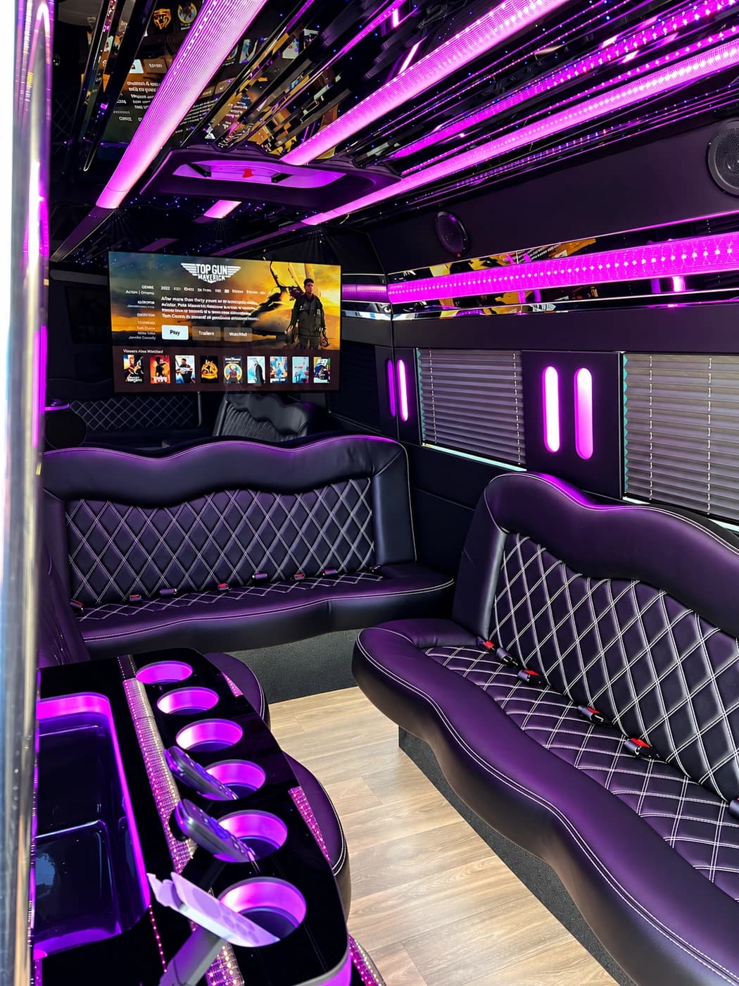 Mercedes-Benz Party Limo Sprinter with purple diamond-stitched seats, a mounted TV and illuminated cup holders.