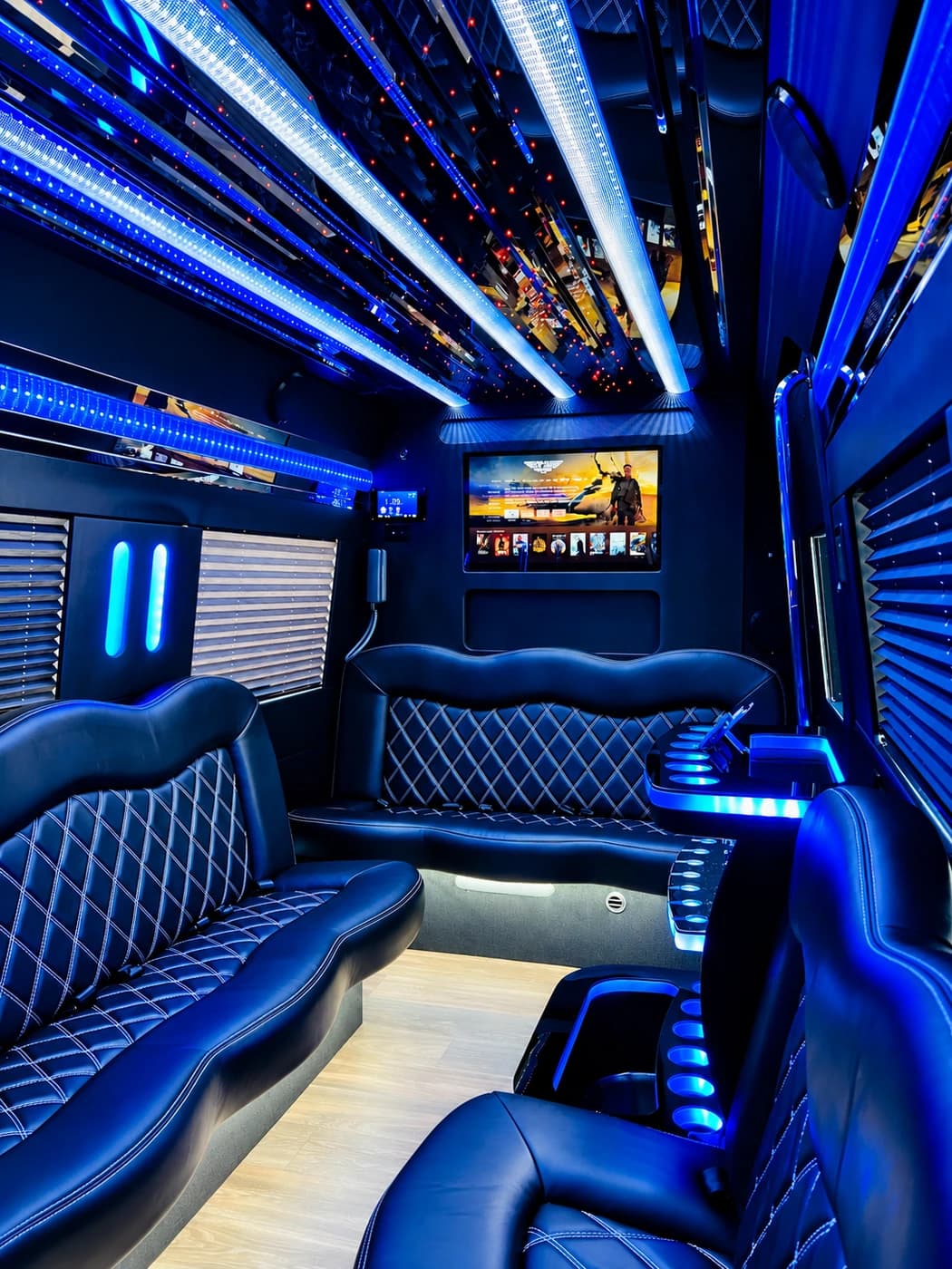 Mercedes-Benz Party Limo Sprinter with diamond-stitched black leather wraparound seats, blue LEDs, a mirrored ceiling and TV.
